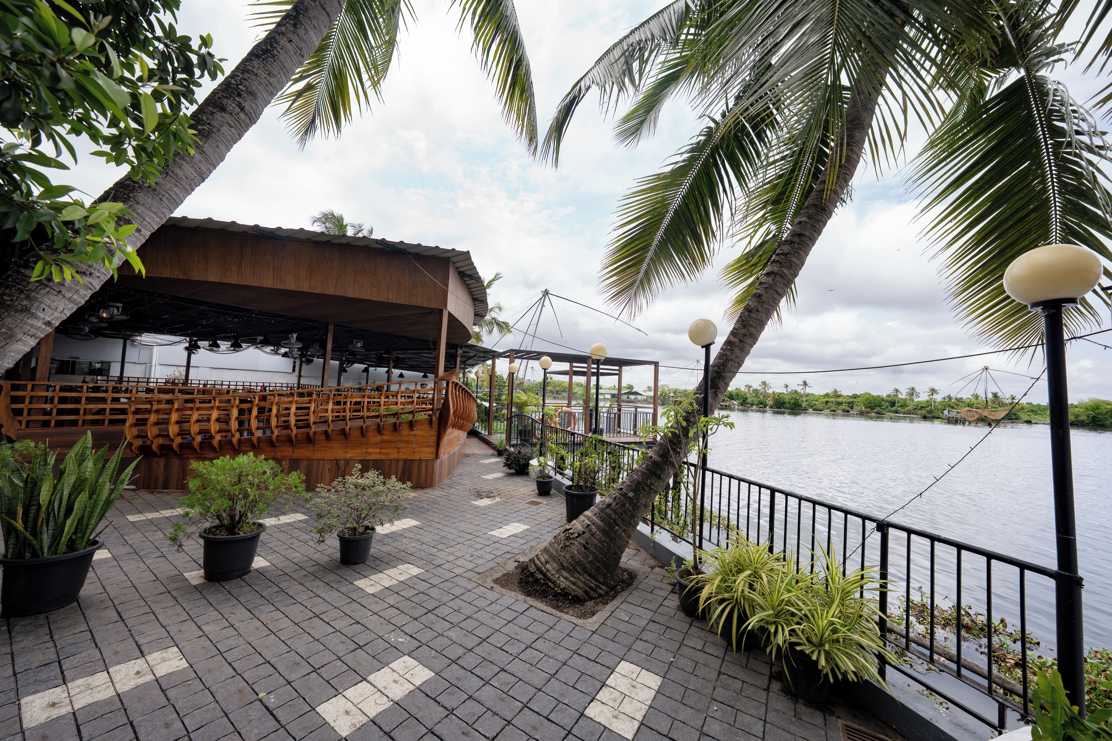 A waterfront restaurant with outdoor seating, a wooden deck, and a view of the water.