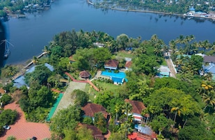 An aerial view of a residential area with houses, a large body of water, and surrounding greenery.