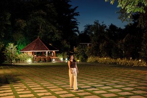 A person standing on a paved area with a gazebo in the background.
