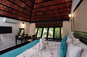 A hotel room with a bed, a desk, a television, and a window with curtains.