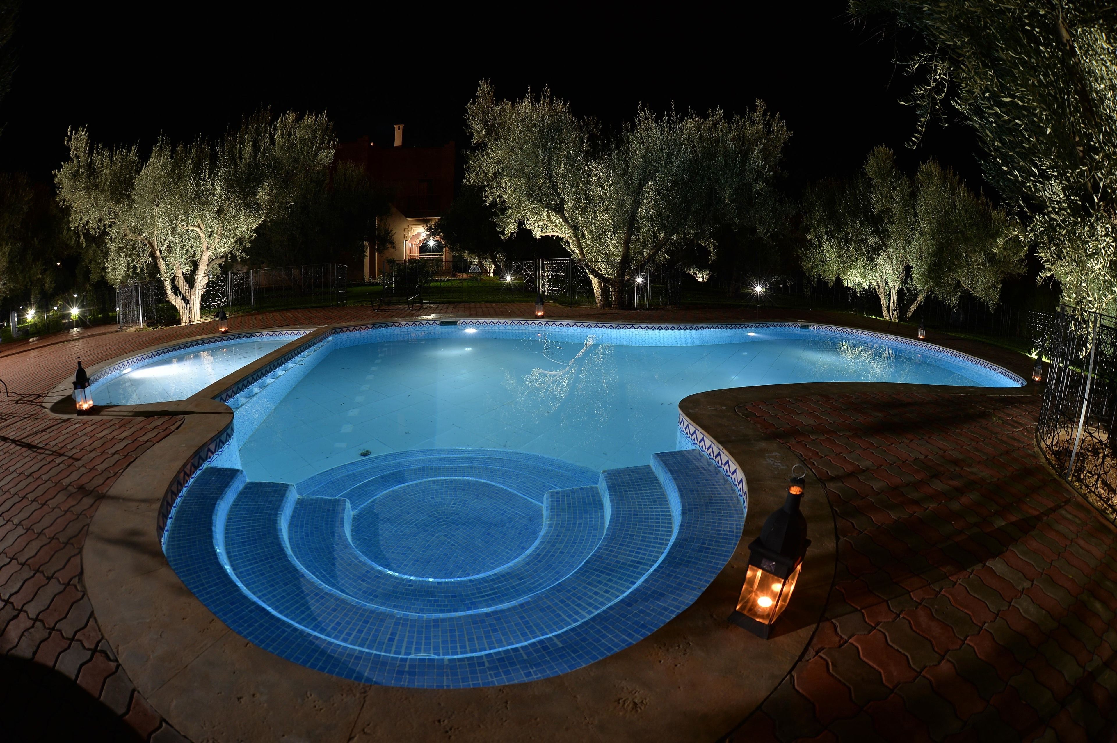 Una piscina al aire libre, sombrillas, sillones reclinables de piscina