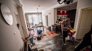 A spacious kitchen with modern appliances, a dining area with a large table, and a living room with a large clock on the wall. - Suite Donna (Bihac)