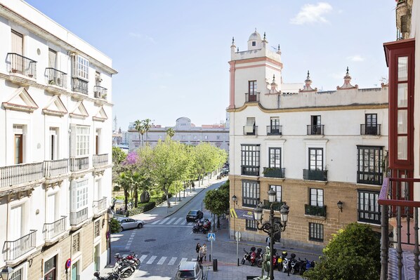 A street view with buildings, a crosswalk, and parked vehicles.
