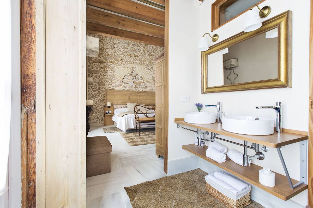 A bathroom with a large mirror, two sinks, and a wooden vanity.