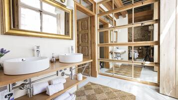 A modern bathroom with two large sinks, a large mirror, and wooden beams.