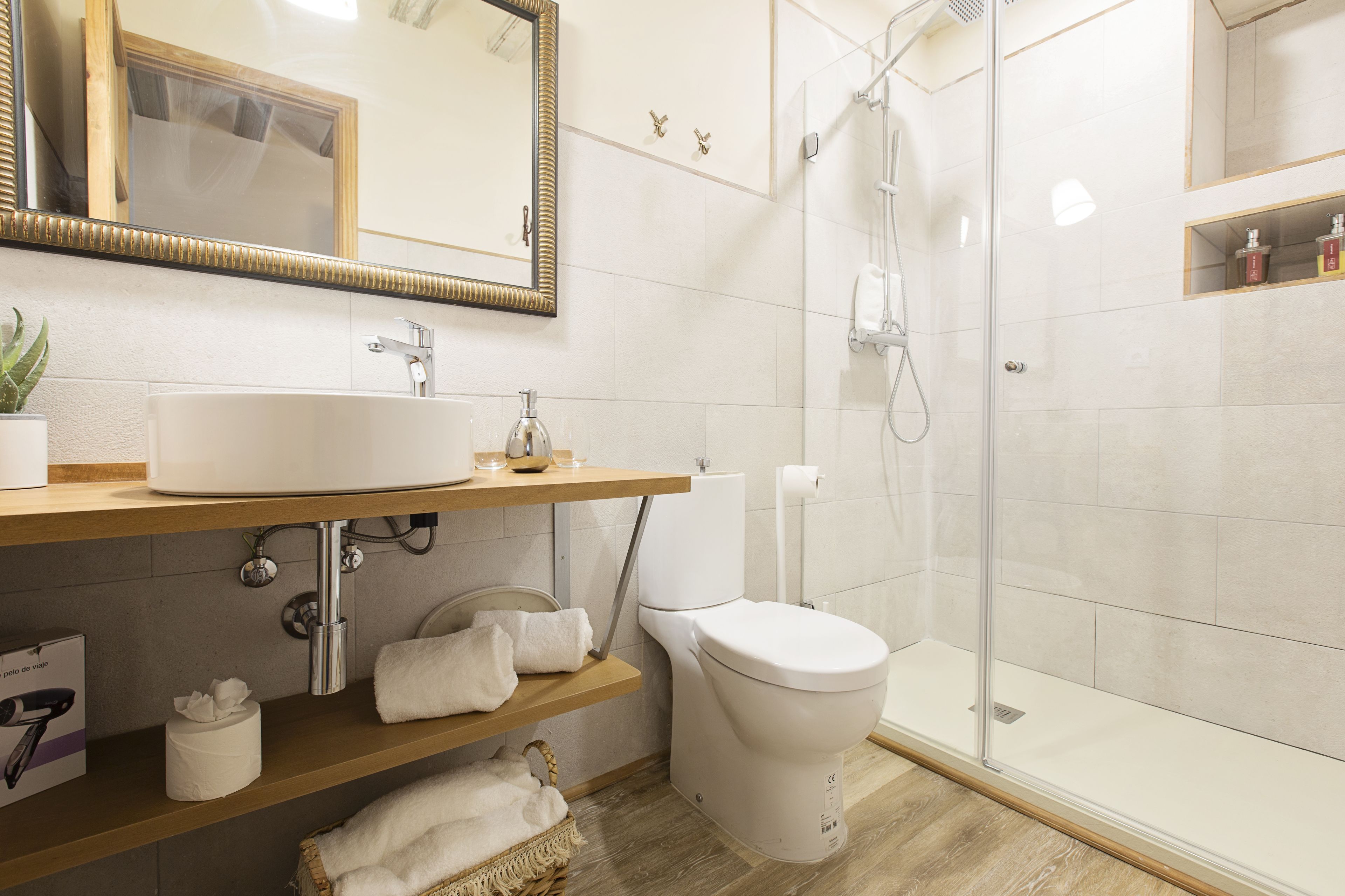 Et moderne badeværelse med en stor vask, toilet og glas brusekabine.