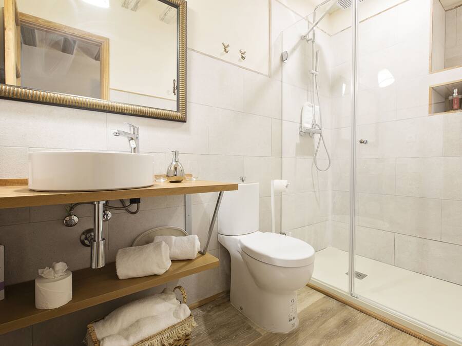 Et moderne badeværelse med en stor vask, toilet og glas brusekabine.