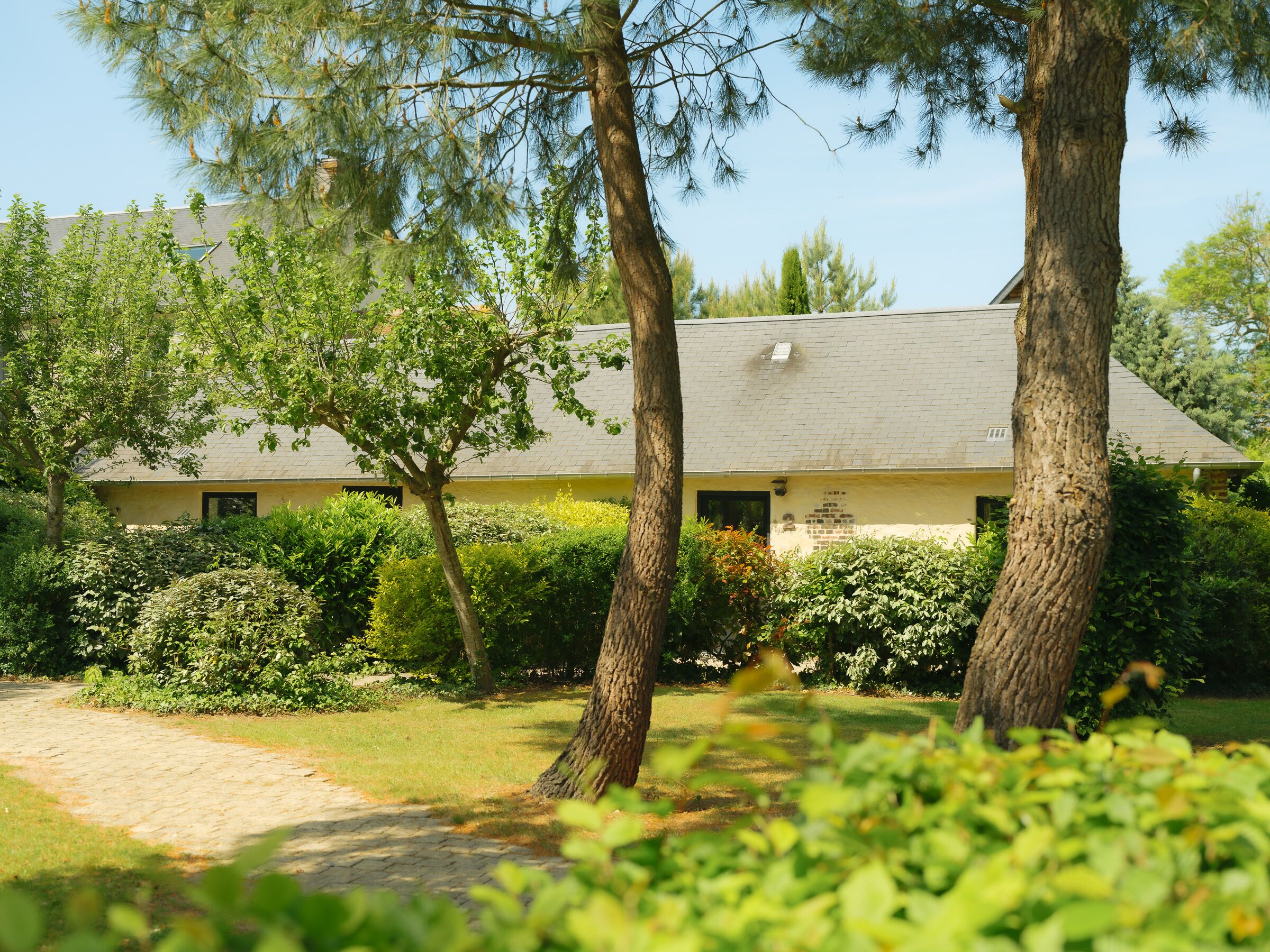 A building with a brick roof, surrounded by trees and greenery.