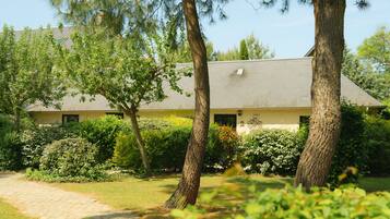 A building with a brick roof, surrounded by trees and greenery.