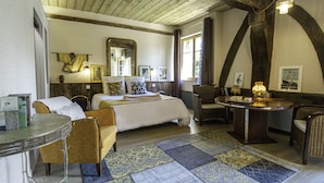 Een knus slaapkamer met een groot bed, een tafeltje en een stoel.