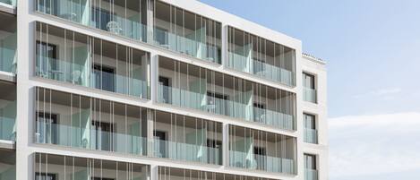 A multi-story building with balconies, large windows, and a modern architectural design.