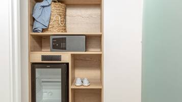 Cocina compacta con microondas, un refrigerador pequeño y un estante con zapatos y un paño azul.