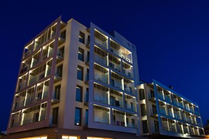 Un hotel de varios pisos con balcones y ventanas amplias.