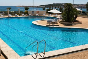 Una piscina al aire libre, tumbonas