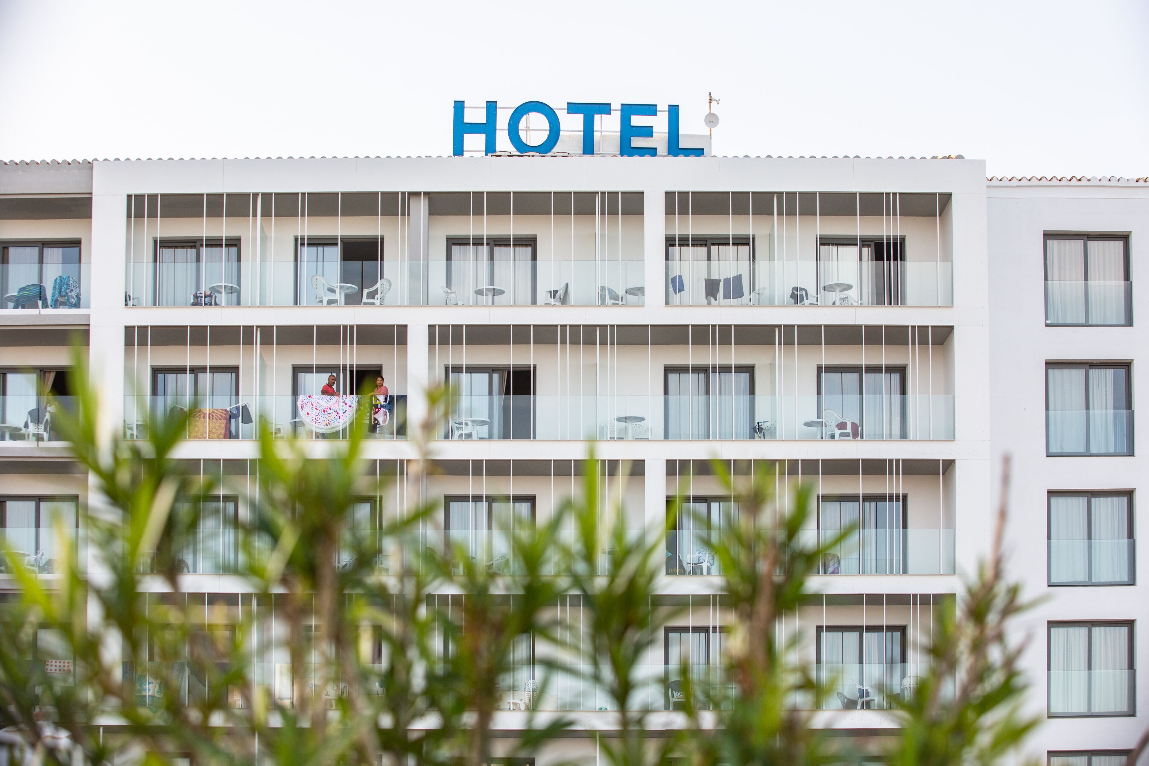 Un edificio di un hotel su più piani, con un cartello ben visibile con la scritta 'HOTEL' in cima.