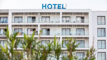 Un edificio di un hotel su più piani, con un cartello ben visibile con la scritta 'HOTEL' in cima.