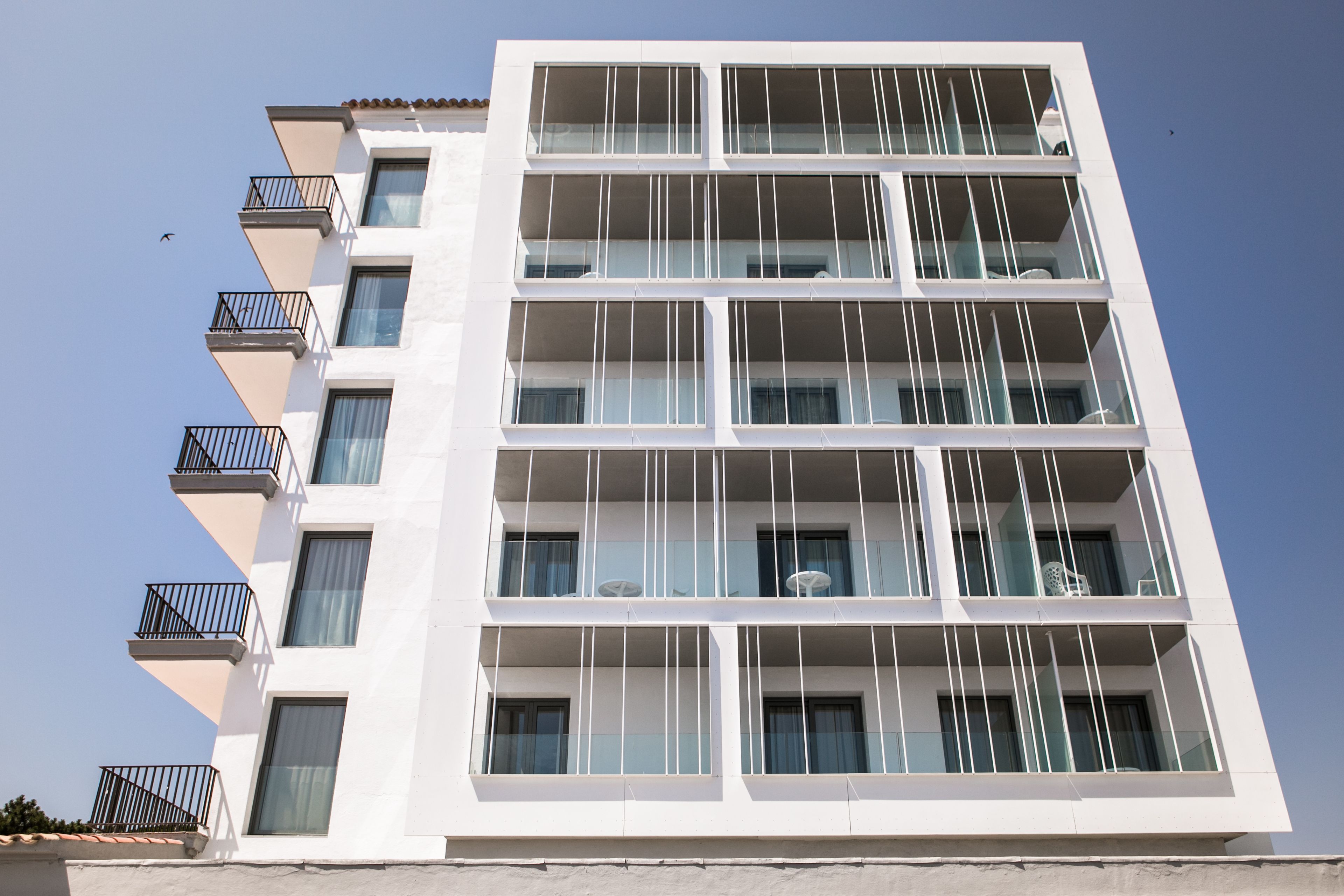 Un immeuble à plusieurs étages doté de balcons et de grandes fenêtres.