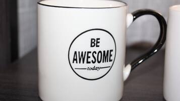 Una taza blanca con asa negra y la frase motivacional 'BE AWESOME today' impresa.