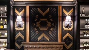 A bar area with a fireplace, two chairs, and a patterned floor. - Hotel Wersal (Zakopane)