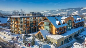 A modern hotel with multiple floors, large windows, and a ski resort backdrop. - Hotel Wersal (Zakopane)