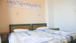 A double bed with a patterned bedspread, two pillows, and a nightstand with a lamp. - Meandros (Apokoronas)