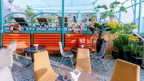 Een dakterras met zitplaatsen, planten in potten en reddingsboeien.