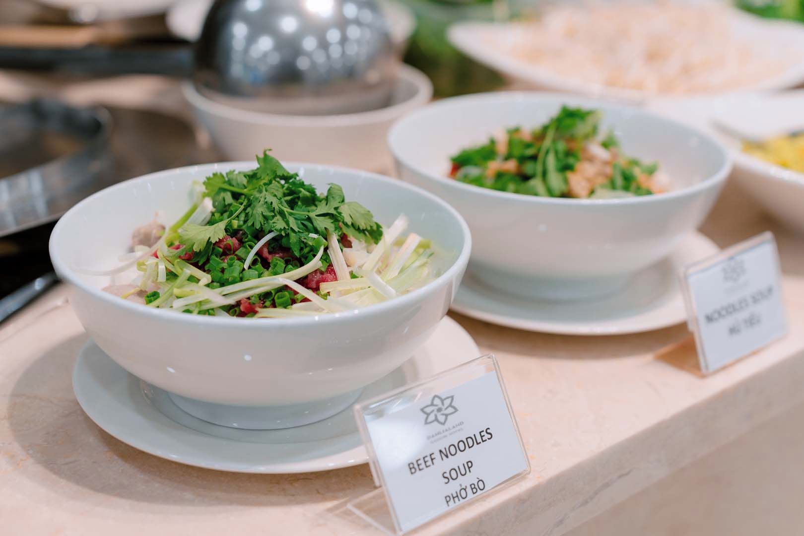 A food display with bowls of beef noodles soup and a sign indicating the dish name.