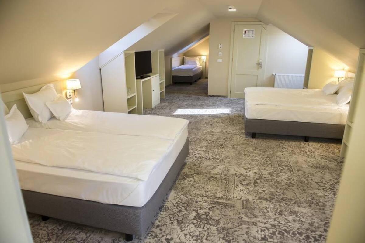 Une chambre d’hôtel avec deux lits, une télévision, une armoire et une petite salle de bain.