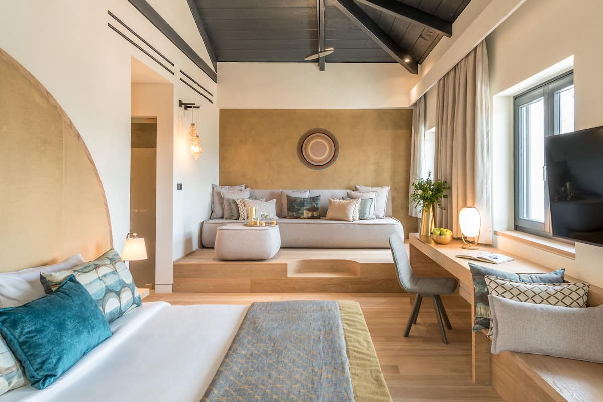 Une chambre d’hôtel moderne équipée d’un grand lit, d’un canapé, d’un bureau et d’une télévision.