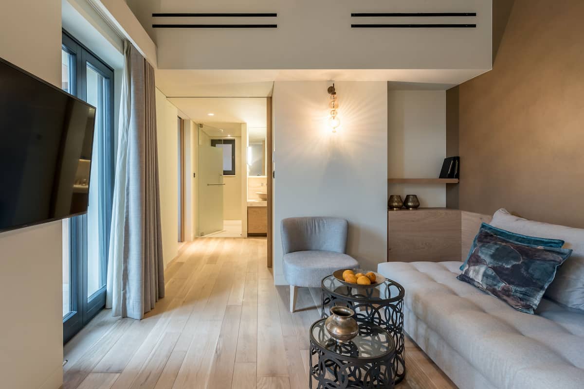 Un salon moderne avec un canapé, une table basse et un téléviseur.