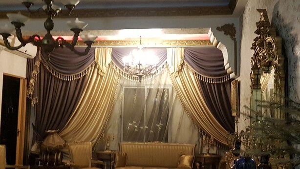 A room with a sofa, chairs, a table, and a decorative mirror. - Appartement Rashed (Tunis)