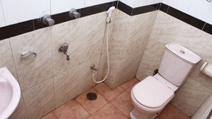 Une petite salle de bain avec des toilettes, un lavabo et une douche.