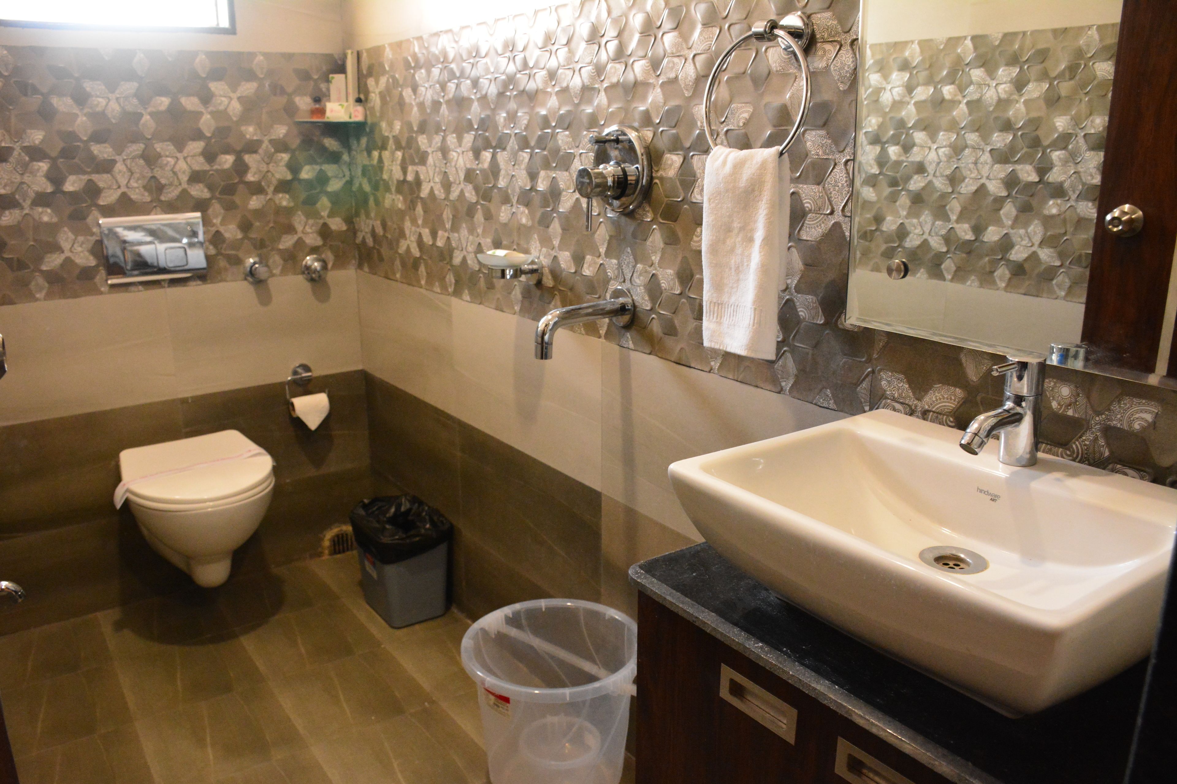 Une salle de bain avec des toilettes, un lavabo et une douche.