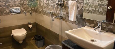 Une salle de bain avec des toilettes, un lavabo et une douche.