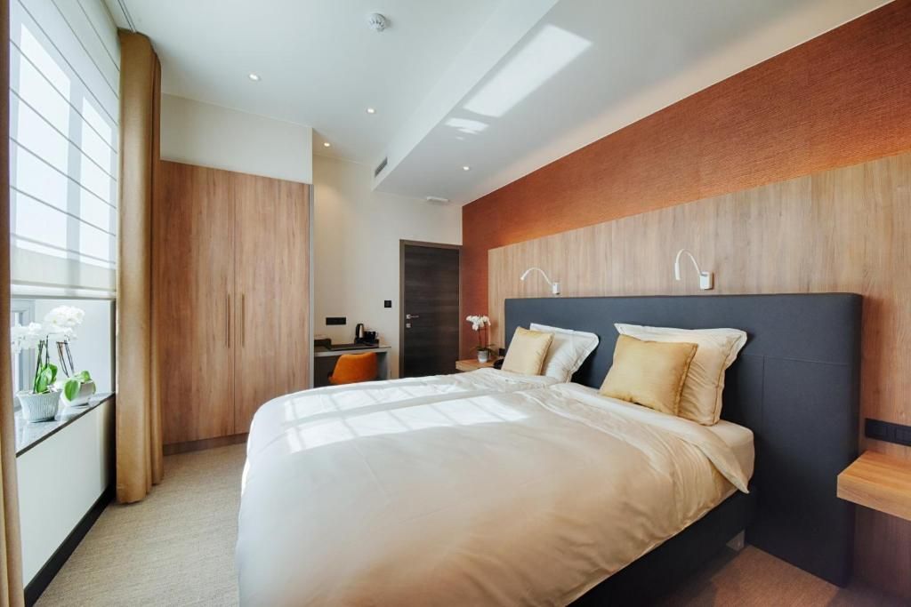 Habitación de hotel moderna con una cama grande, un escritorio y vistas a la ciudad.
