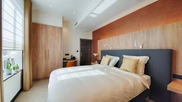 Habitación de hotel moderna con una cama grande, un escritorio y vistas a la ciudad.