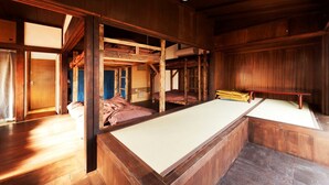 Una habitación tradicional japonesa con suelo de tatami, literas de madera y una mesa baja de tatami.