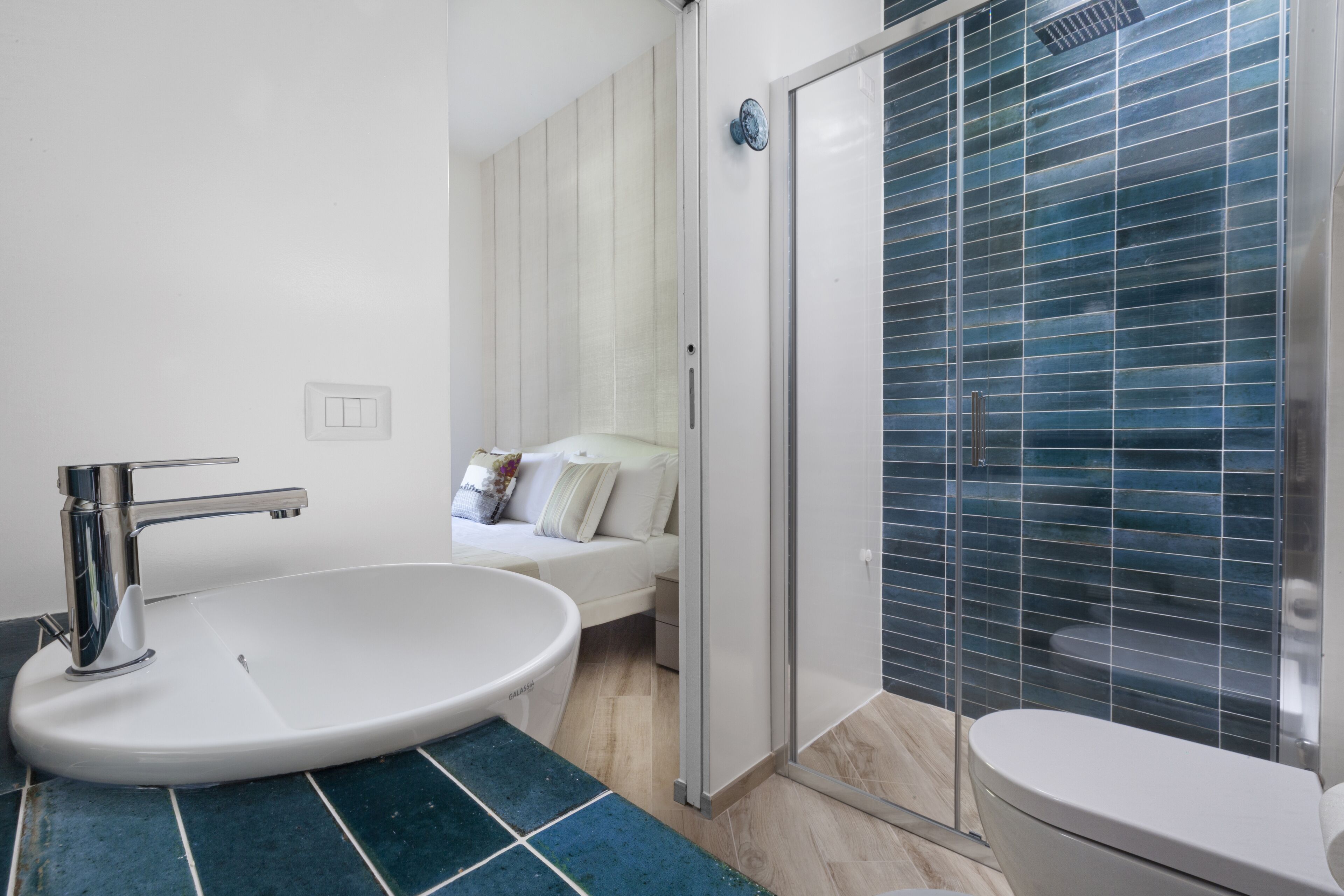 A bathroom with a white sink, a shower enclosure, and a toilet.