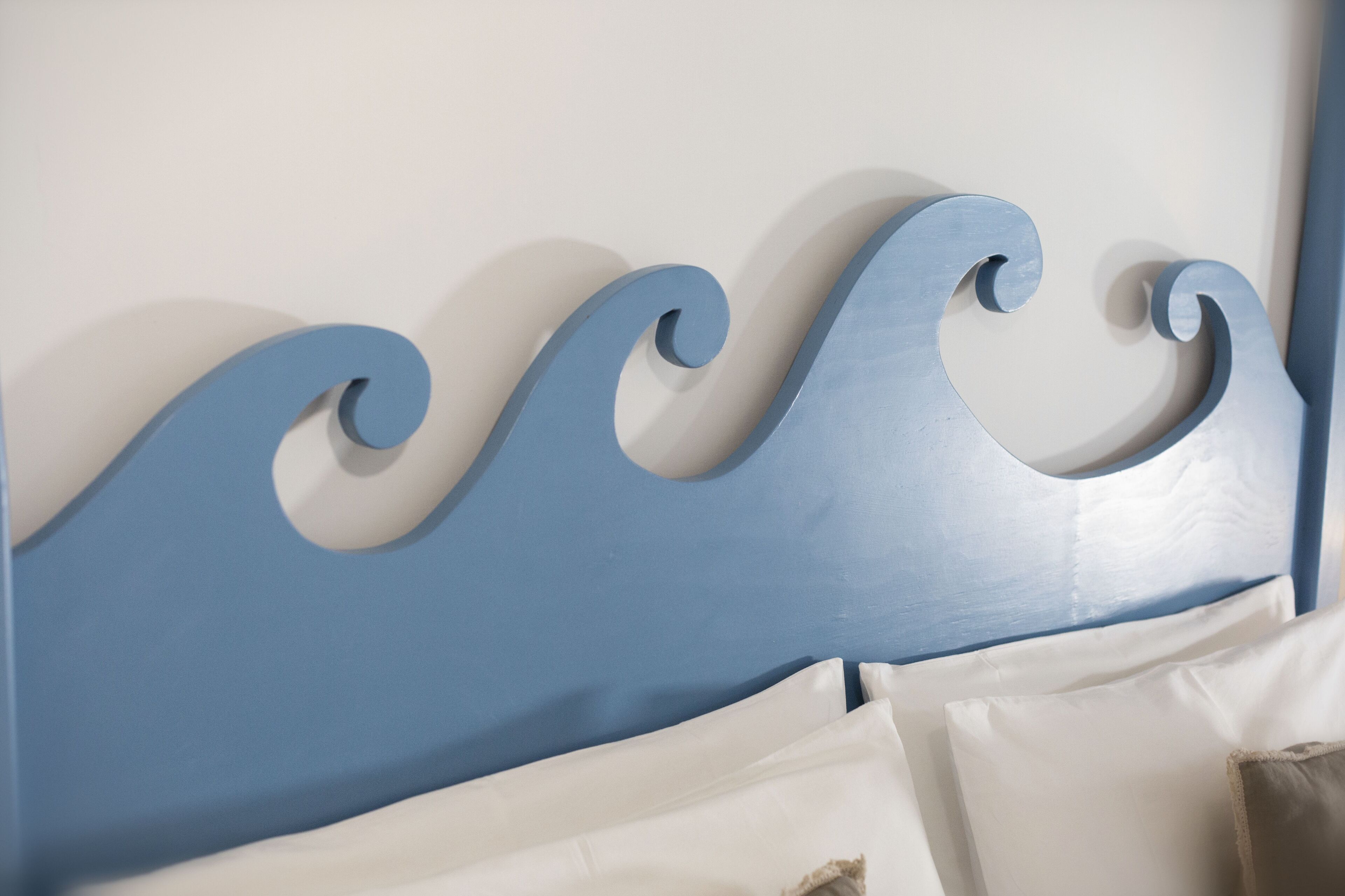 A bed with a blue headboard and white bedding.