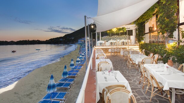A seaside restaurant with outdoor seating overlooking the beach and water. - Hotel Il Cefalo (Castellabate)