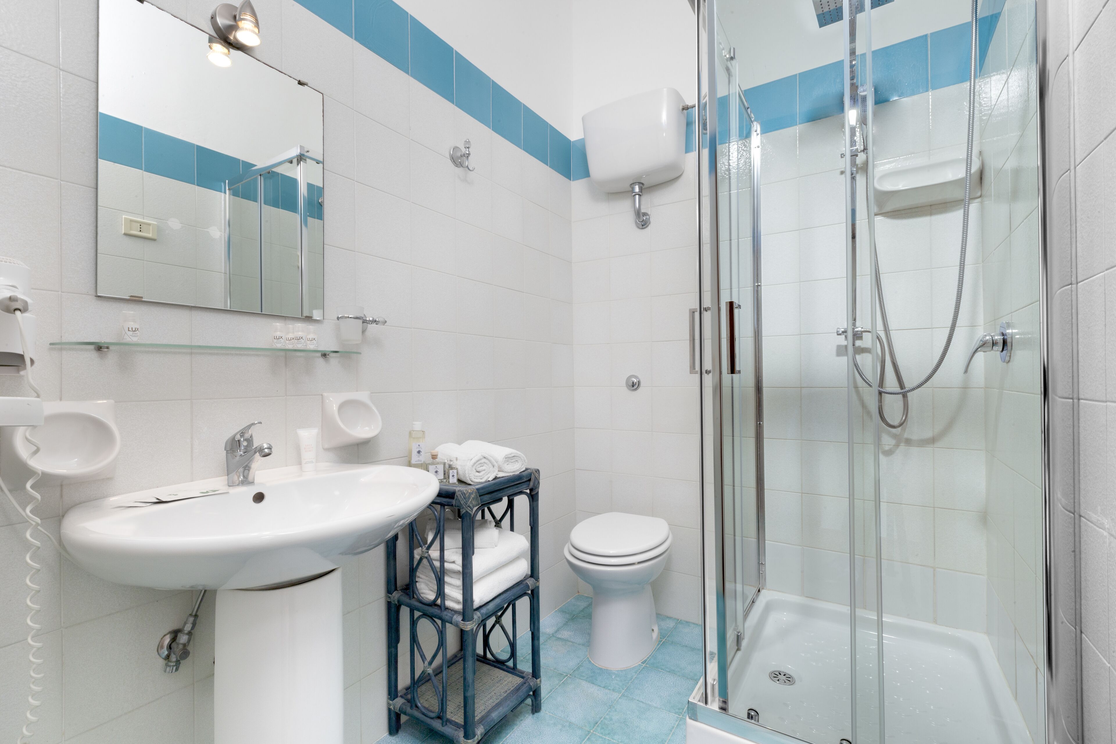 A bathroom with a white sink, a glass shower enclosure, and a toilet.
