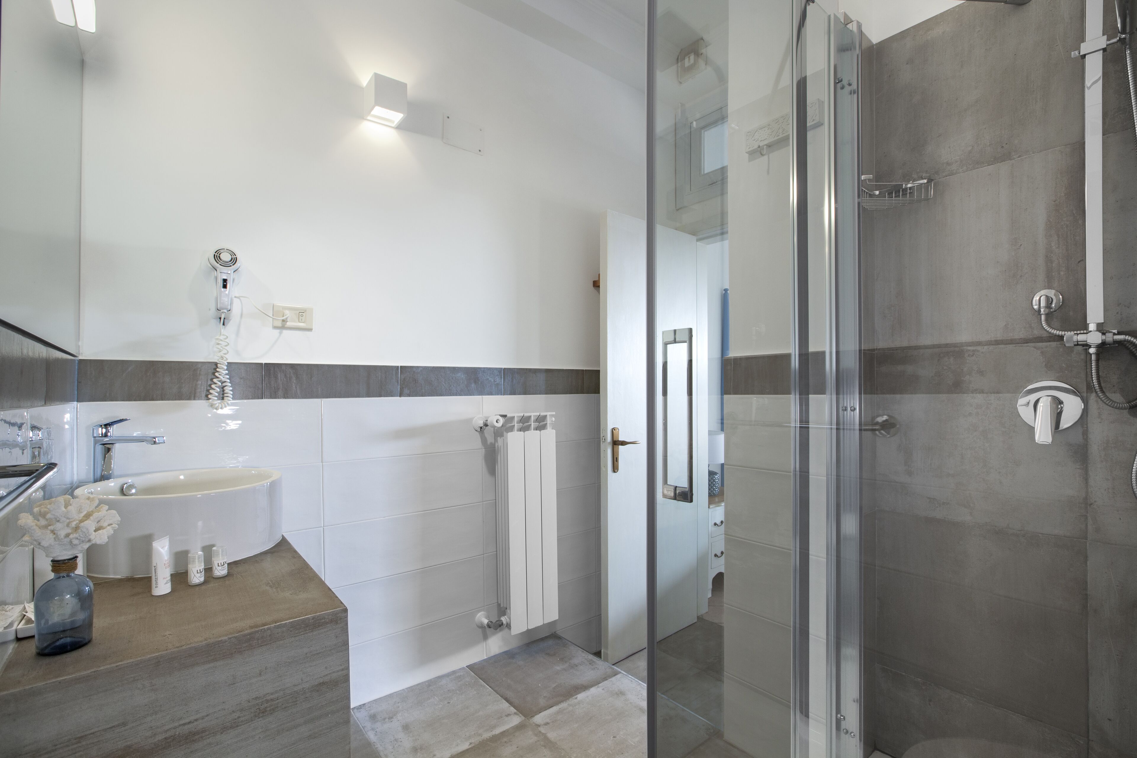 Et moderne badeværelse med et glasbadeværelsesafskærmning, en fritstående vask og et indbygget toilet.