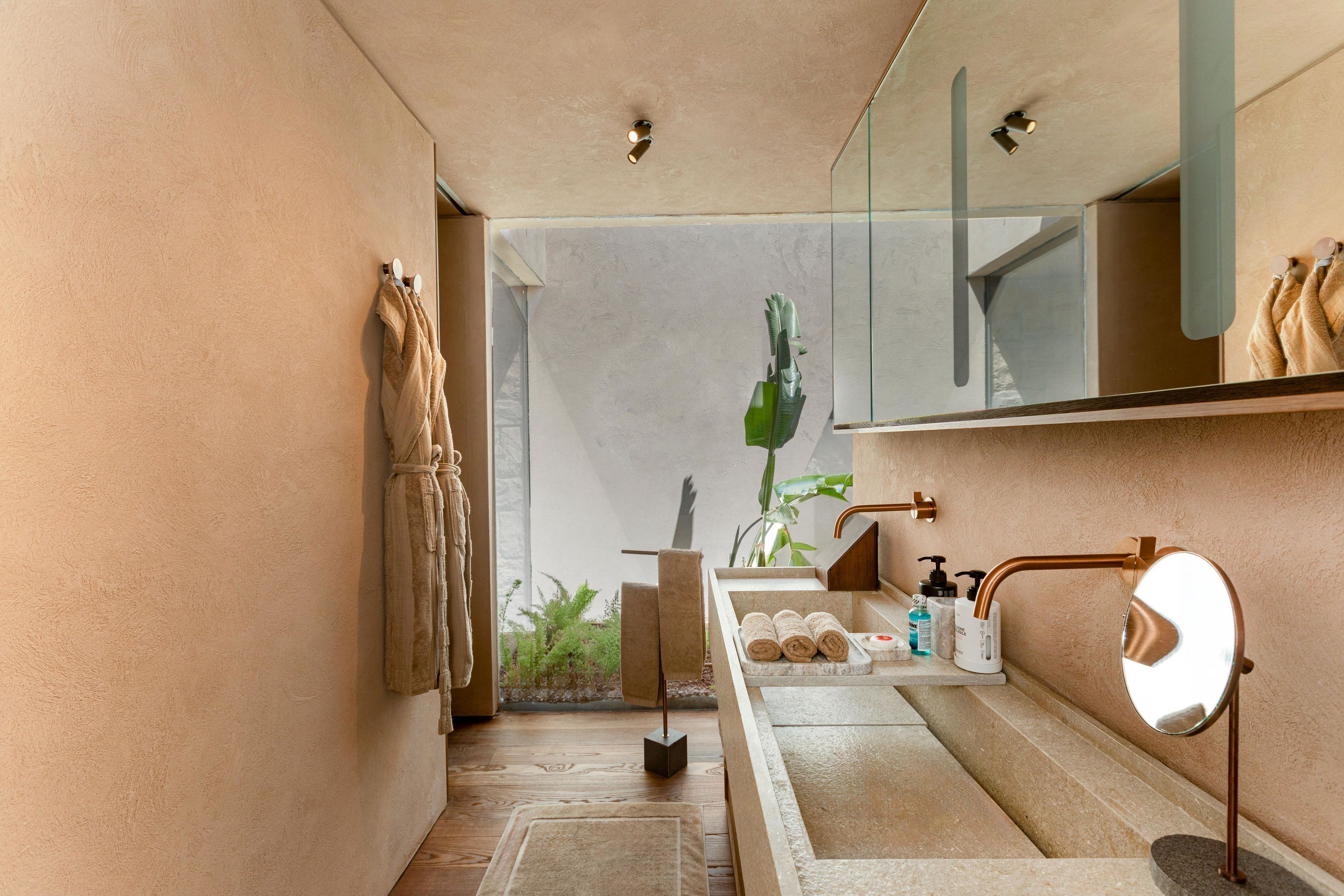 Un baño moderno con cabina de ducha de vidrio, un lavamanos con espejo y un perchero para toallas.