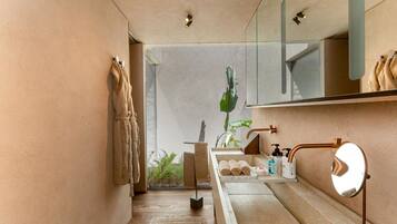 Un baño moderno con cabina de ducha de vidrio, un lavamanos con espejo y un perchero para toallas.