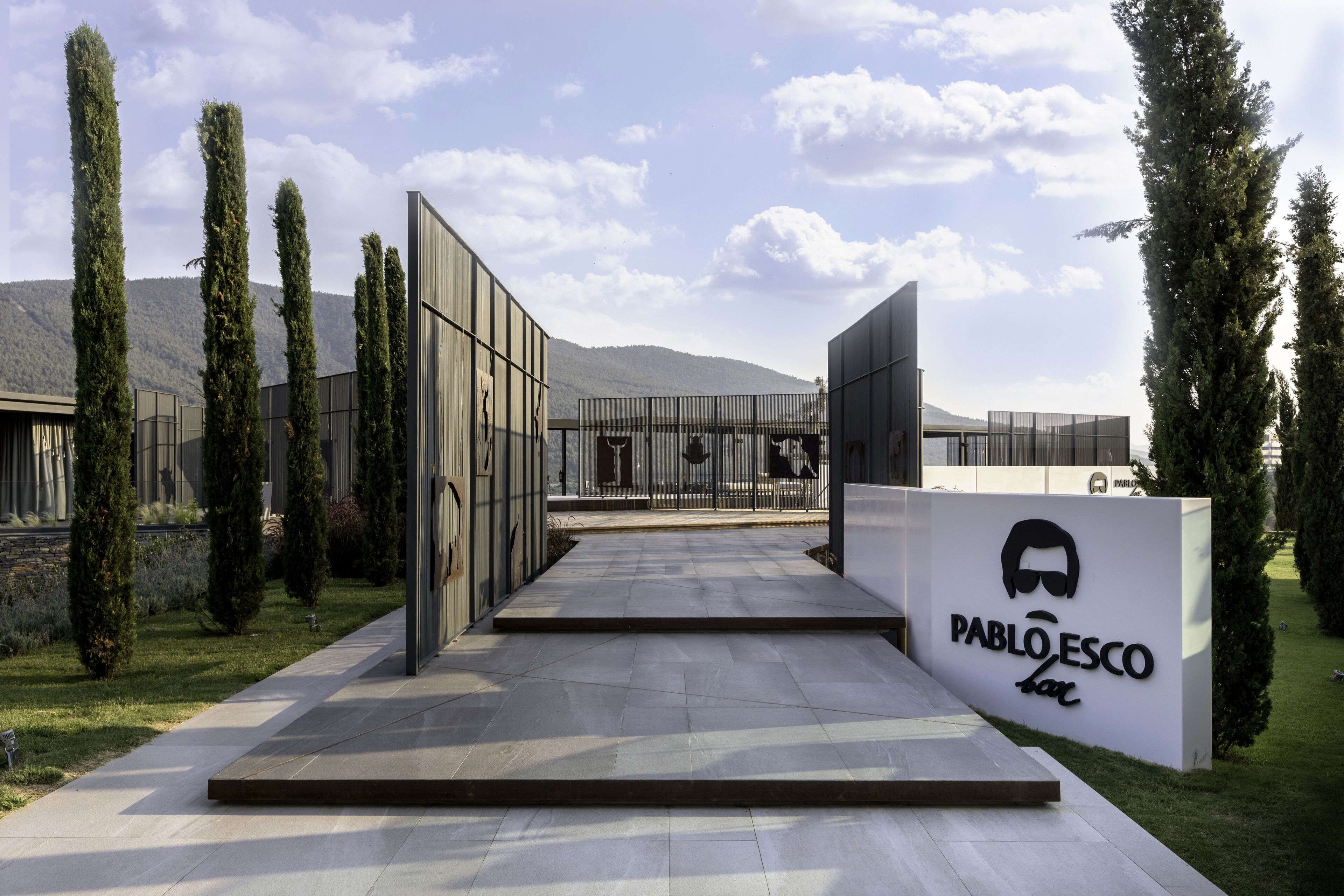 A modern building with a sign reading "PABLOESCO bar".
