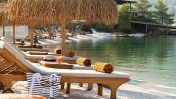 Playa privada, playa de arena blanca y camas de playa (con cargo)