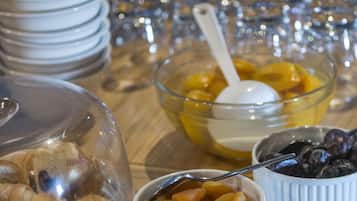 A breakfast buffet with various food items including fruits, pastries, and a selection of beverages.