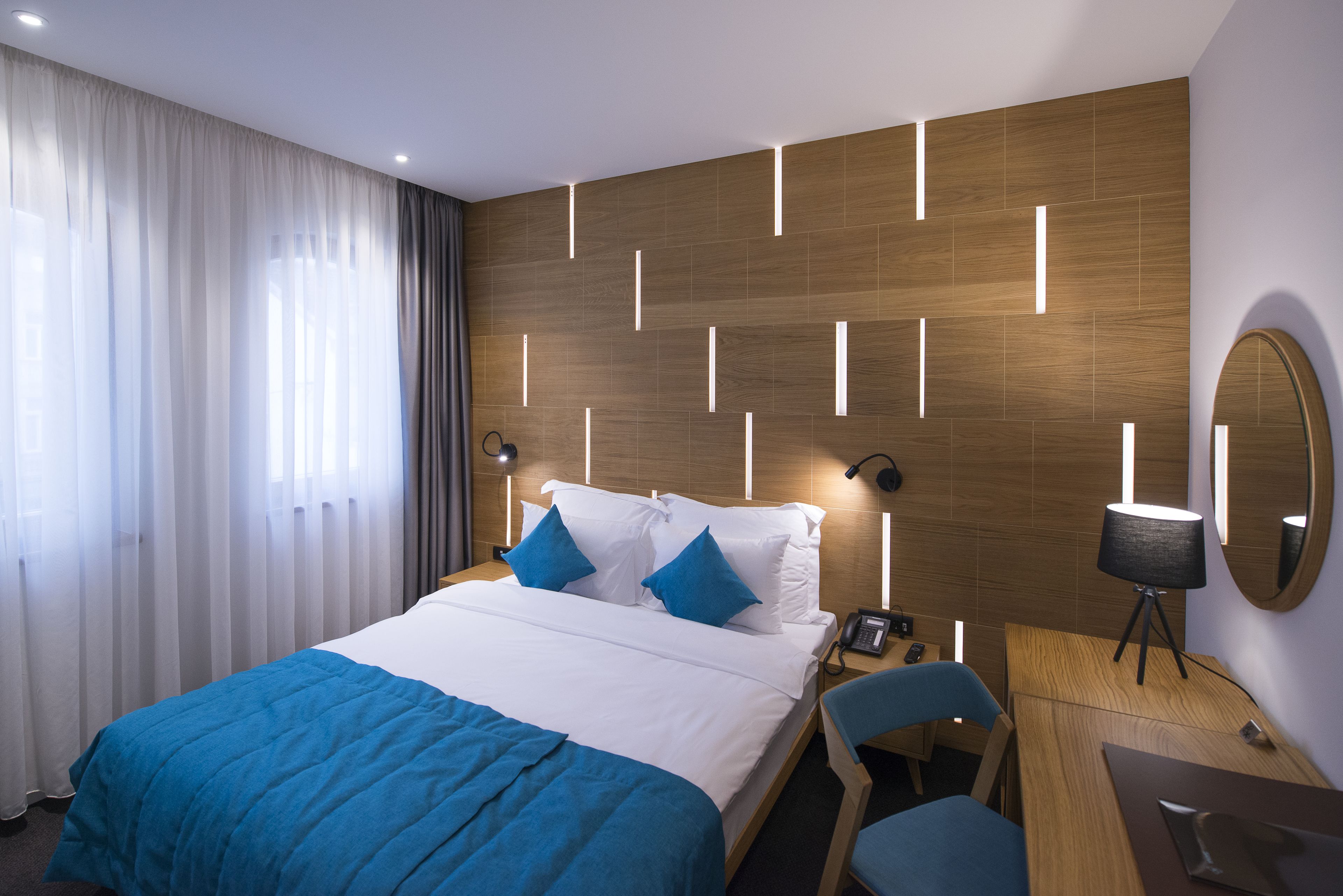 Ett modernt hotellrum med en stor säng, ett skrivbord och en stol.