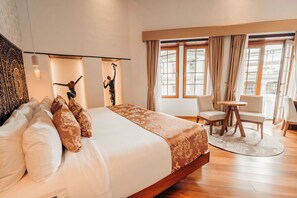 A hotel room with a large bed, a small round table, and two chairs. - Hotel Mama Cuchara by Art Hotels Ecuador (Quito)