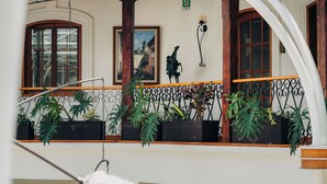 A balcony with potted plants, a wooden railing, and a view of the street. - Hotel Mama Cuchara by Art Hotels Ecuador (Quito)